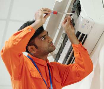 A technician setting up an air conditioner in Dubai.